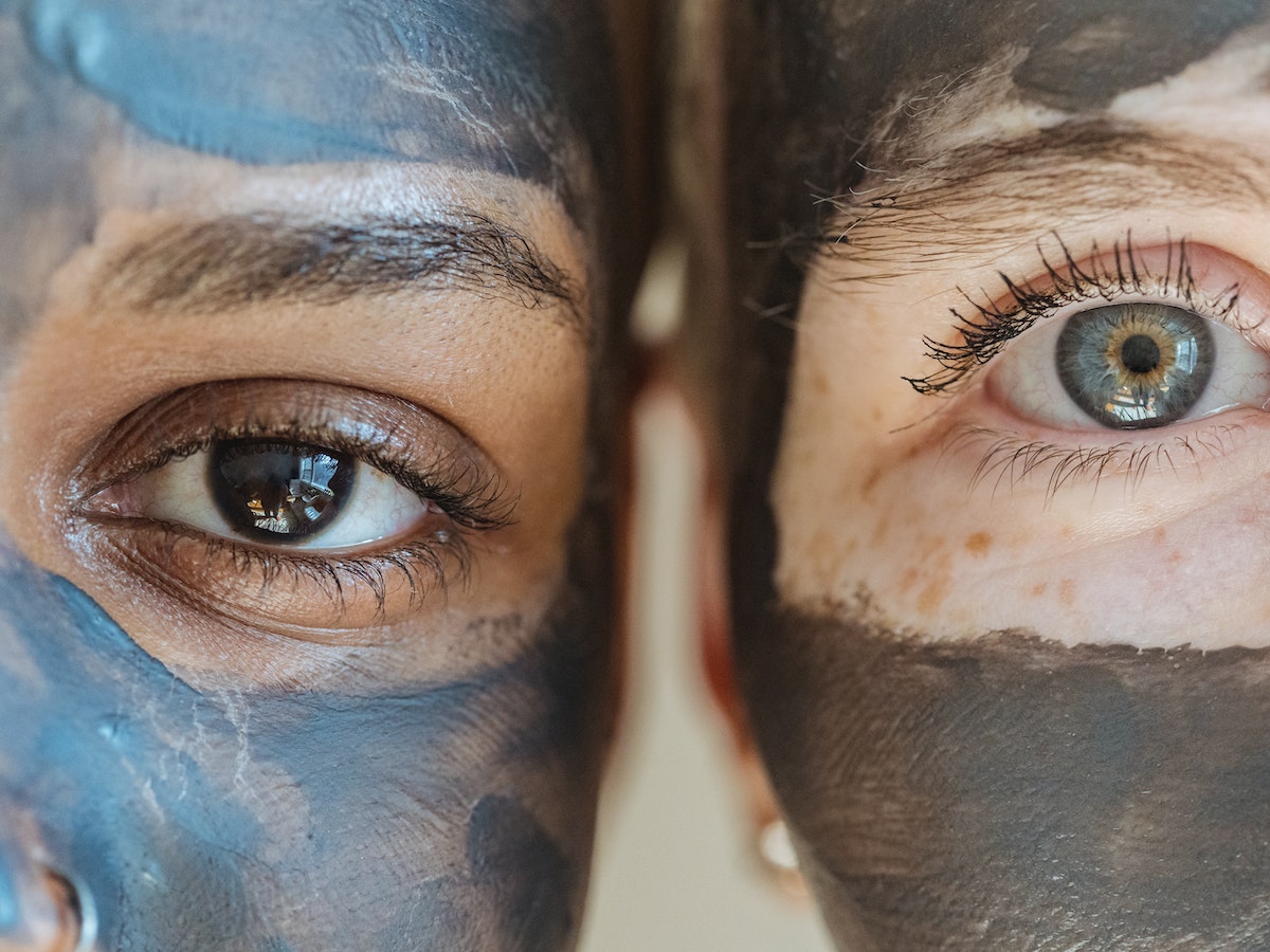 Close-up of two young women's eyes with the application of anti-aging cream.