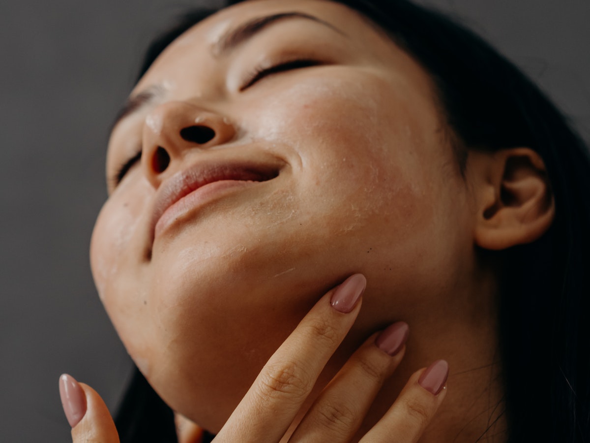 Focused young woman diligently following her daily skincare routine for a healthy, radiant complexion.